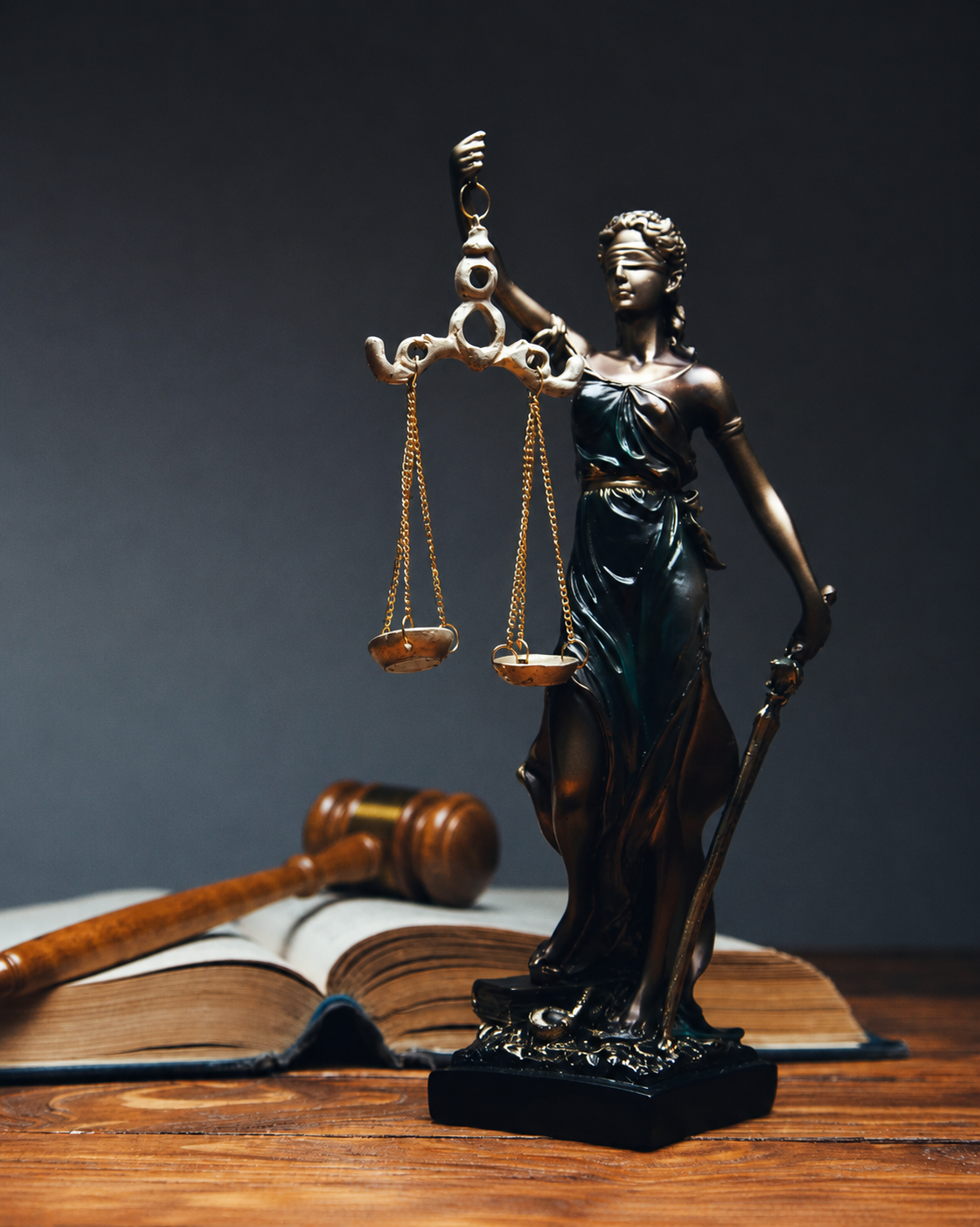 Símbolo da Justiça representado por uma estátua sobre livros jurídicos